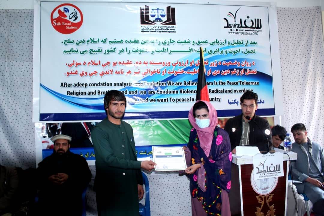 A female participant of the event receiving her certificate of participation